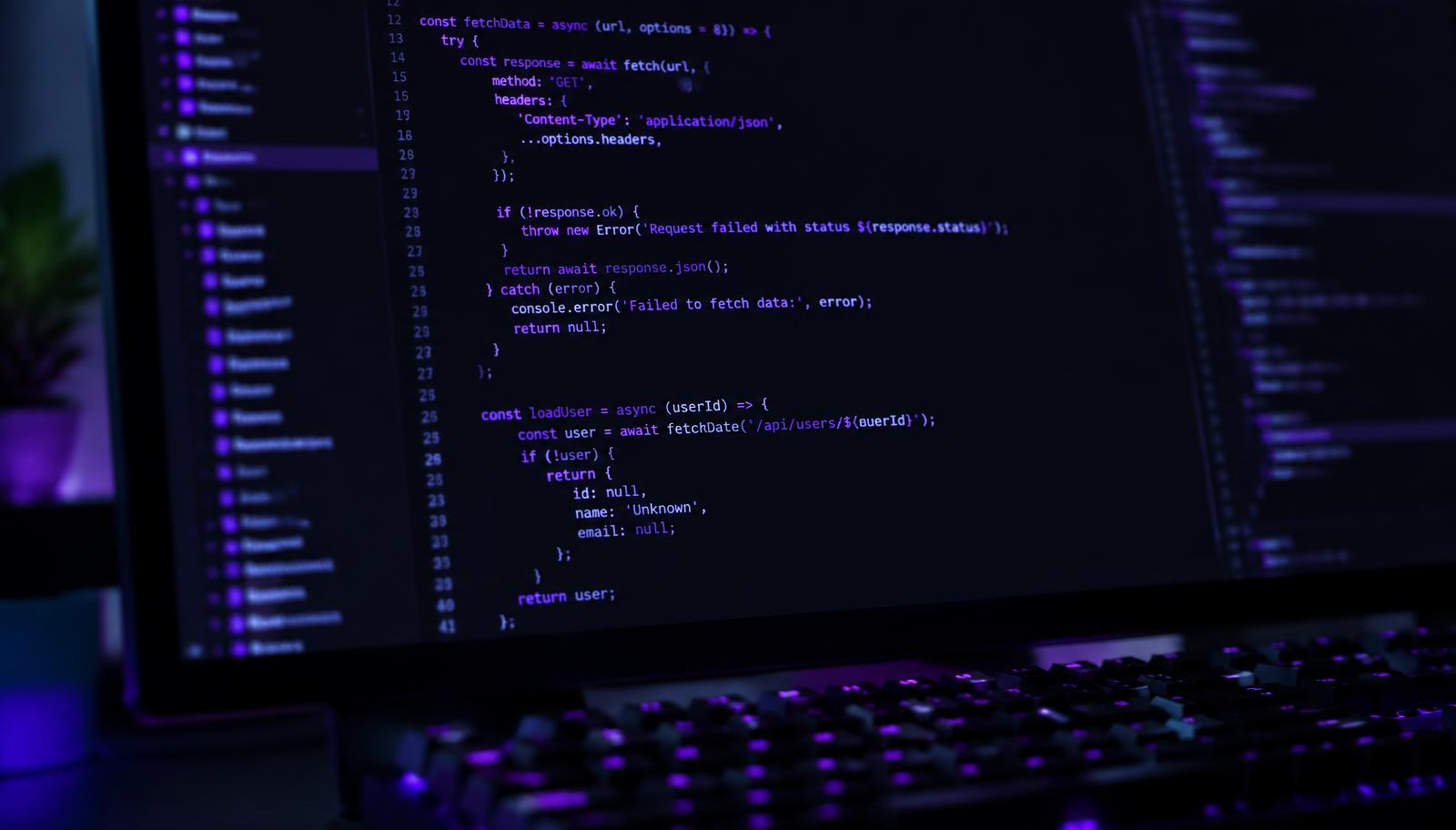 Source code with violet syntax highlighting on a monitor in a dark room